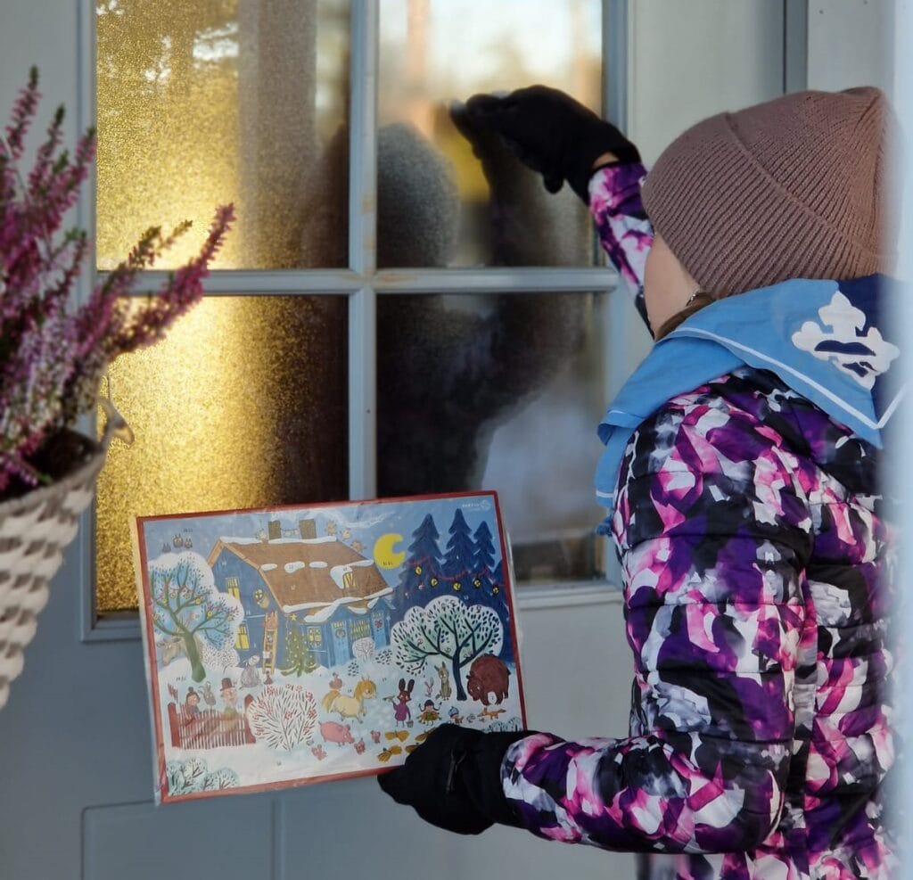 Partiolainen koputtaa ovelle. Kädessä hänellä on adventtikalenteri.