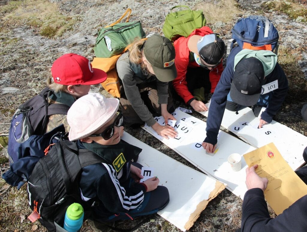 Viisi lasta polvistuneina pelin äärelle.